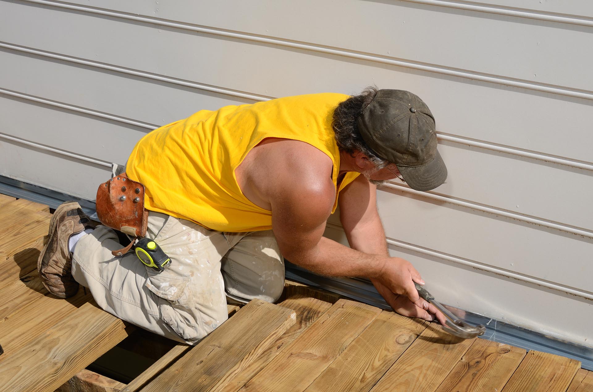 A carpenter hammering on a deck patio