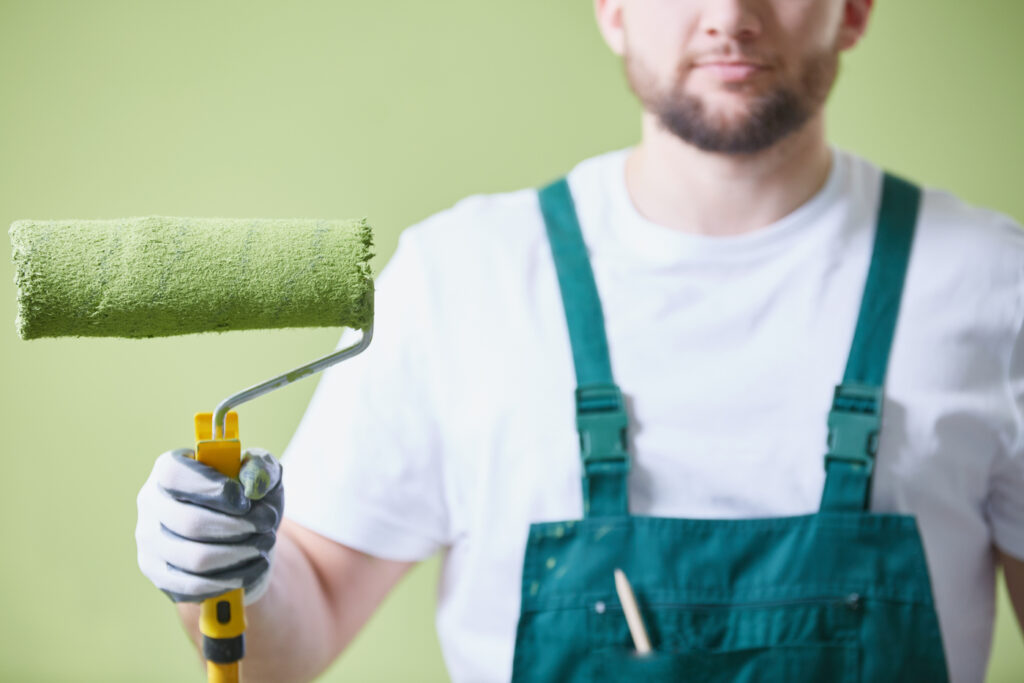 An employee of one of the local painting contractors holding a roller. 