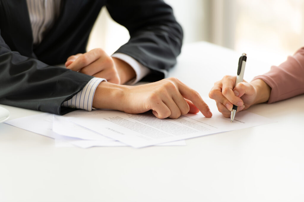 A homeowner signing a written contract on the painting services to be provided. 