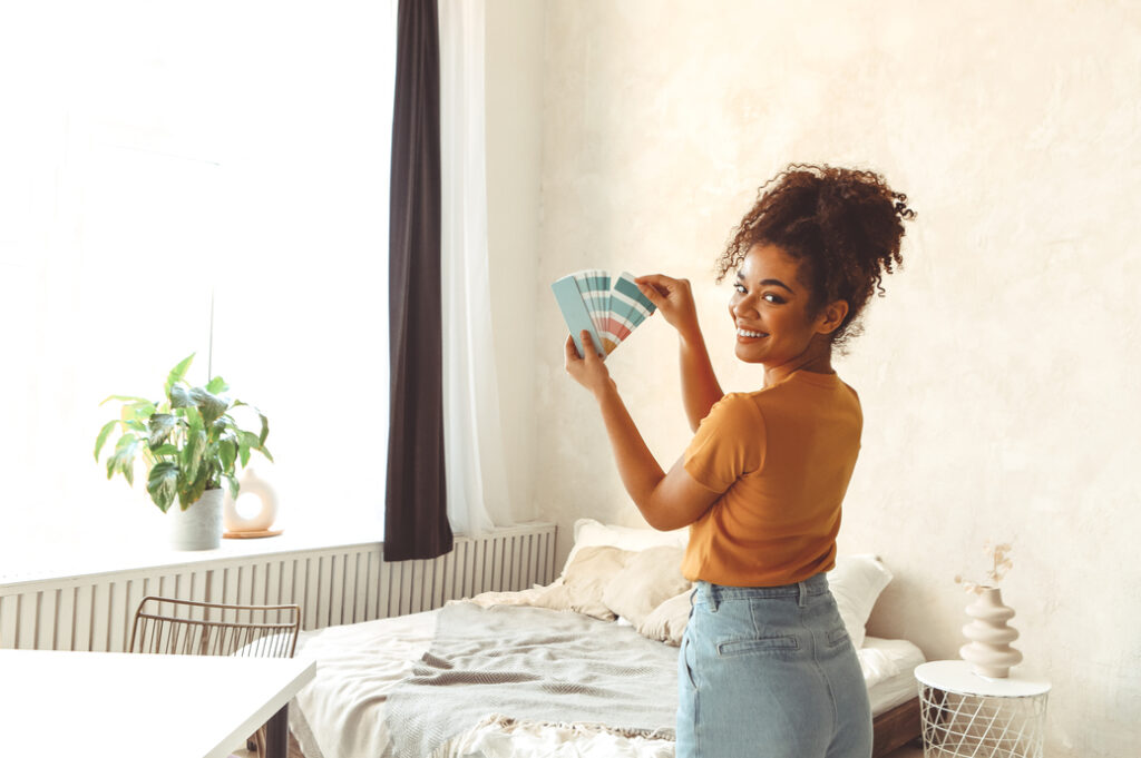 A woman examining different color palettes, which can have an impact on the cost to paint a house.