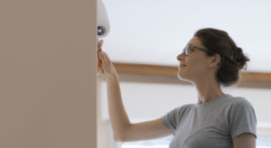 A woman, who has decided to do the exterior painting of her home on her own.