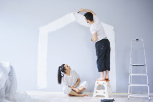 A couple who are in need of quick painting services in Kansas, attempting to paint the walls of their home.