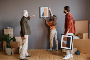 A family hanging paintings on their walls after hiring local residential painting services for their home.
