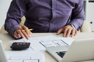 An individual calculating the cost to paint a house.
