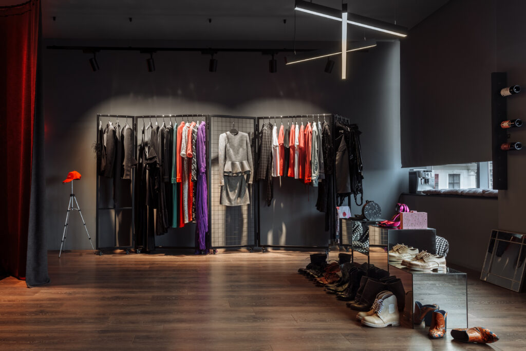 This image showcases a stylish clothing store, with racks of colorful attire and neatly arranged shoes, reflecting the high-end design and layout. It can represent commercial painting in retail spaces, where a well-executed paint job enhances the visual appeal and ambiance, contributing to the overall shopping experience.