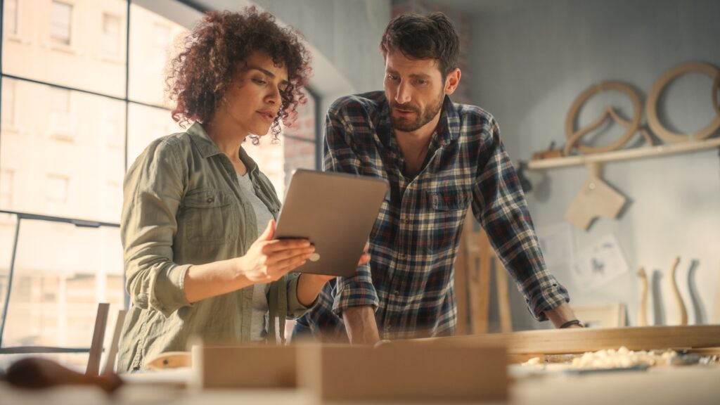 This image shows two professionals collaborating over a tablet in a workspace, suggesting the planning and consultation aspect of commercial interior painting services. It highlights the detailed coordination and decision-making involved in choosing the right services for a commercial project.