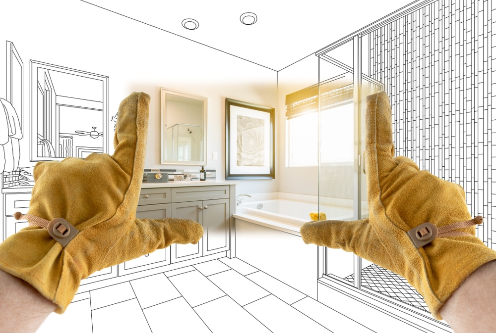 Gloved hands framing a bathroom remodel transitioning from blueprint sketch to finished space, illustrating stages in a home renovation timeline.