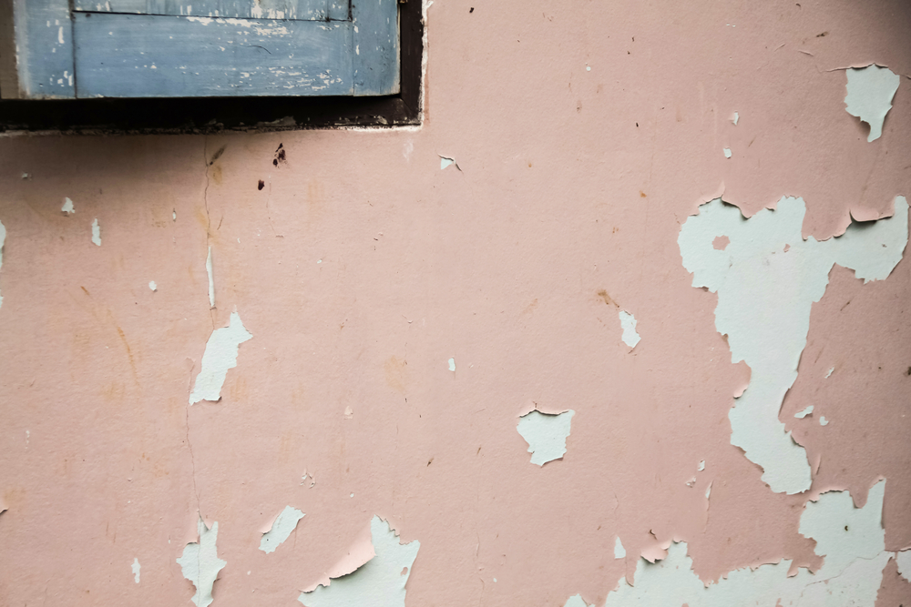 Peeling paint on wall showing a mistake people make when hiring painters with poor prep work.