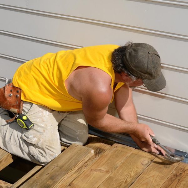 Carpenter Hammering A carpenter hammering on a deck patio